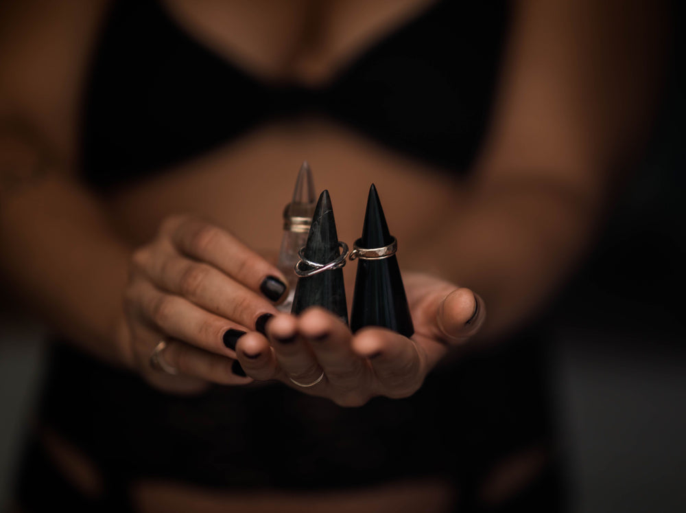 Black obsidian ring holder with rings in palm of hand